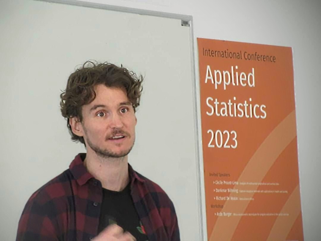 Marjan beside the Applied Statistics 2023 conference banner
